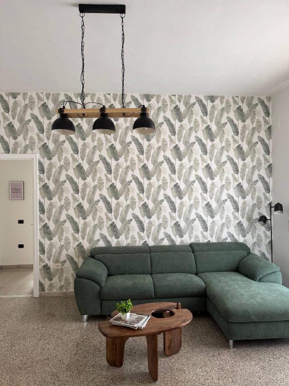 a living room with a green couch and a table at Mary 's Home in Caserta