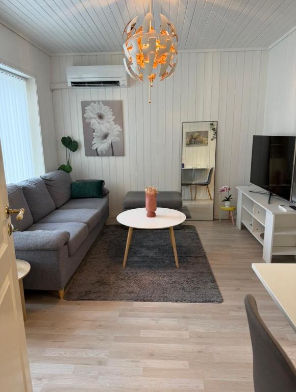 a living room with a couch and a table at Koselig leilighet in Flekkefjord