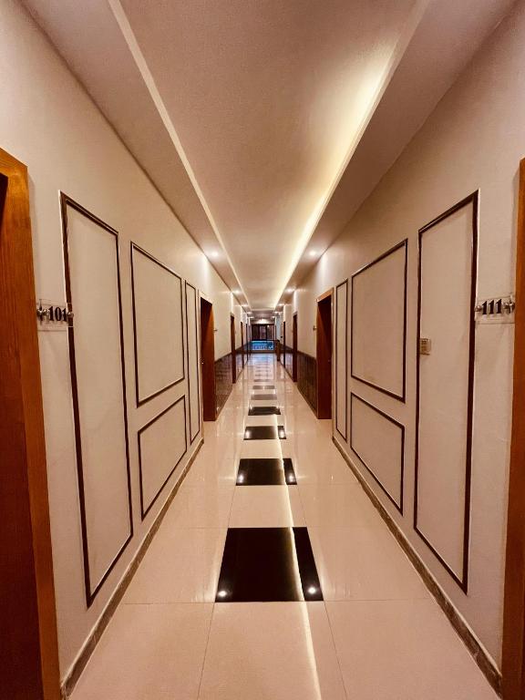 a hallway with a row of doors in a building at Solo Hotel in Sargodha