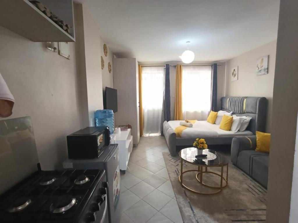 a living room with a couch and a stove at Pearls Haven in Kinoo