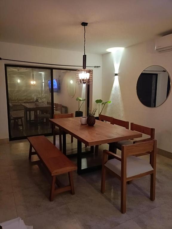 ein Esszimmer mit einem Holztisch und Bänken in der Unterkunft Casa Puzzle in El Nido