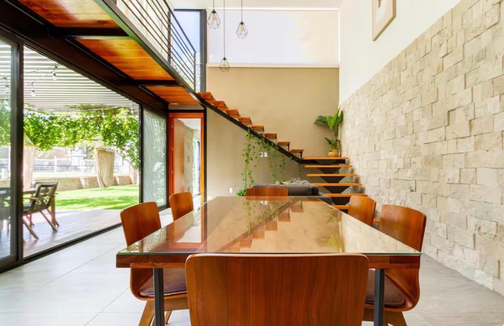 a dining room with a glass table and chairs at CASA CON JACUZZI PRIVADO PARA 6 personas in Tequisquiapan