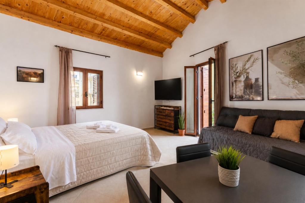 a bedroom with a bed and a couch and a table at La carbonaia rooms in Agrigento in Agrigento