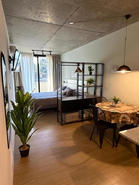 a bedroom with a bed and a table and a dining room at Petit BANFIELD in Banfield