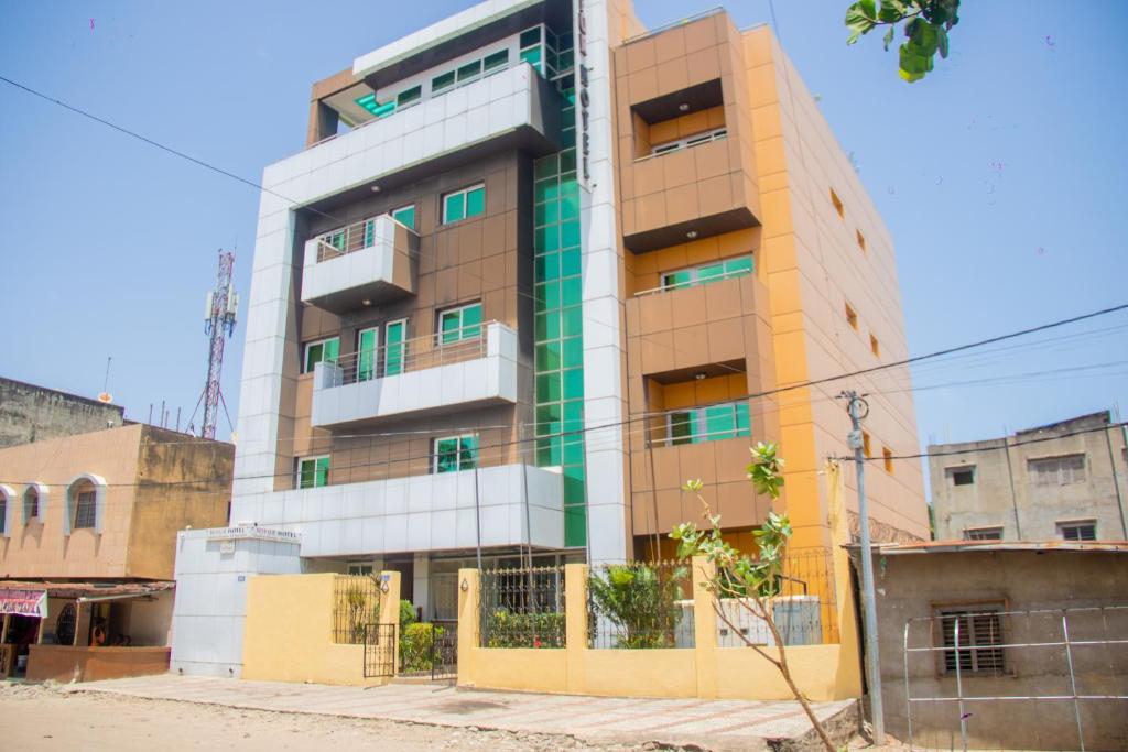 a building in the middle of a city at NI-FUR Hotel Cotonou in Cotonou
