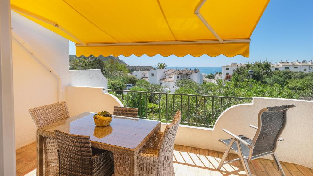a dining room with a table and chairs on a balcony at Vila Vista Luz in Lagos