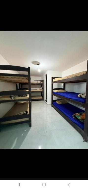 a room with three bunk beds in a room at Terraço Hostel in Cabo Frio
