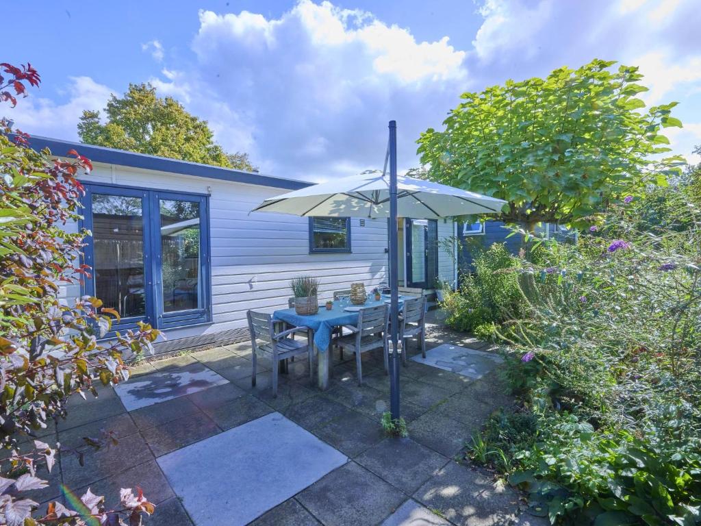 a patio with a blue table and an umbrella at Chalet Sea Birds in Goedereede