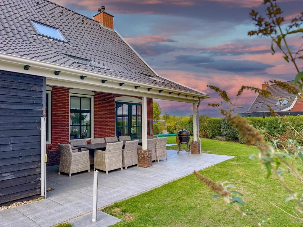 a house with a patio with a table and chairs at Dune Design 38 in Colijnsplaat
