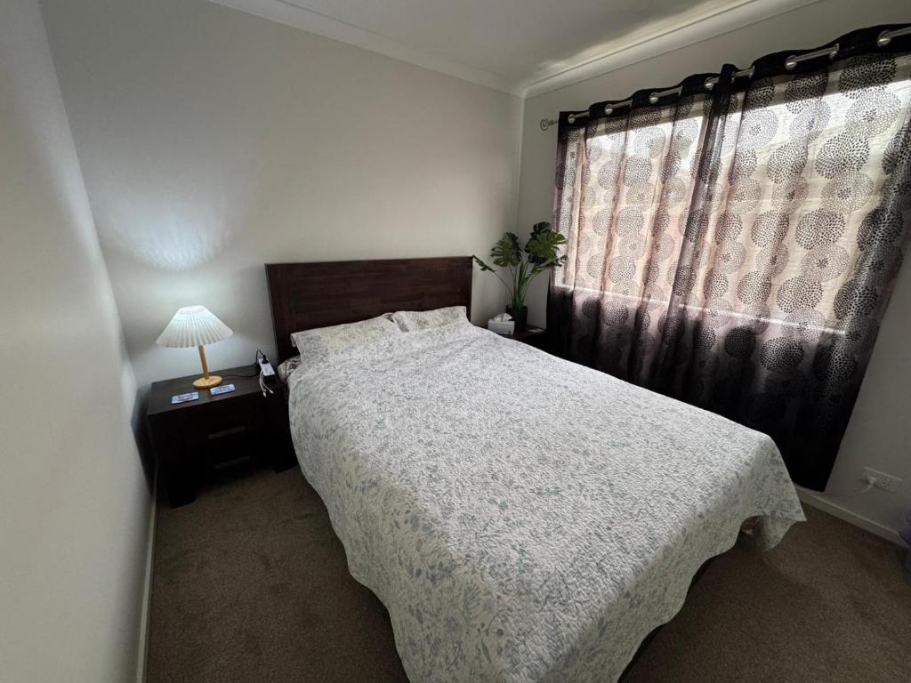 a bedroom with a large bed and a window at Cozy and comfortable room - Geelong suburbs in Grovedale