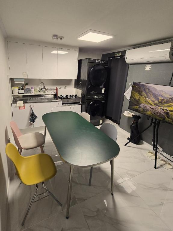 a kitchen with a green table and chairs at Stay GaeBong in Seoul