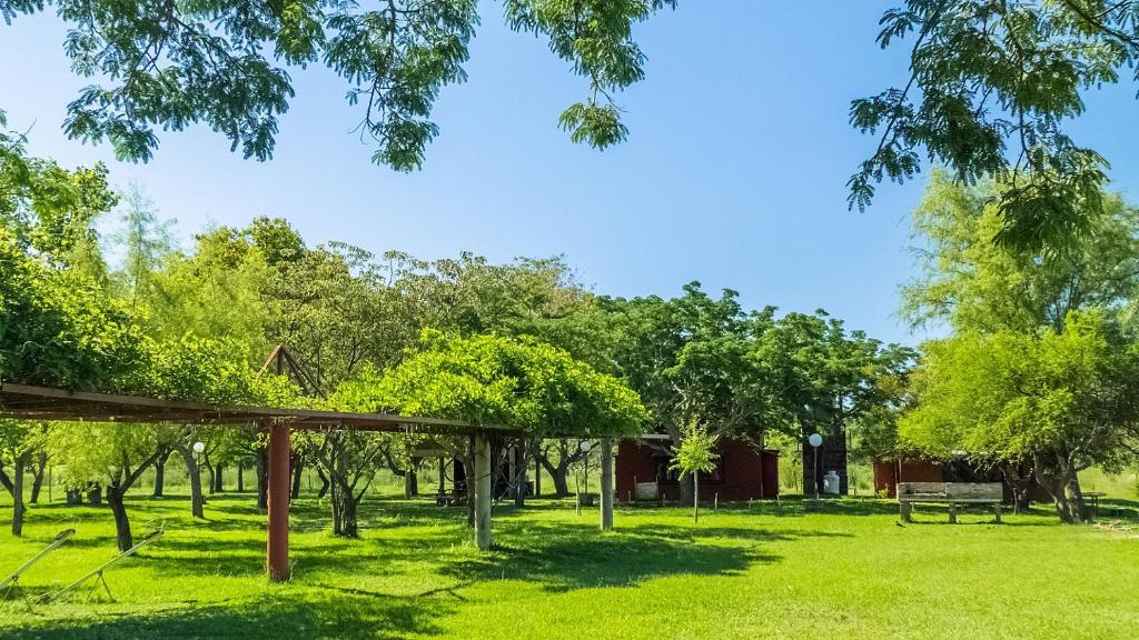 a park with trees and a bench in the grass at Cabañas Las Macluras in Colastiné