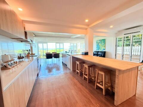 a large kitchen with a large wooden table and chairs at 2BR Oceanview Villas - Slice of Paradise, Central Suva in Suva
