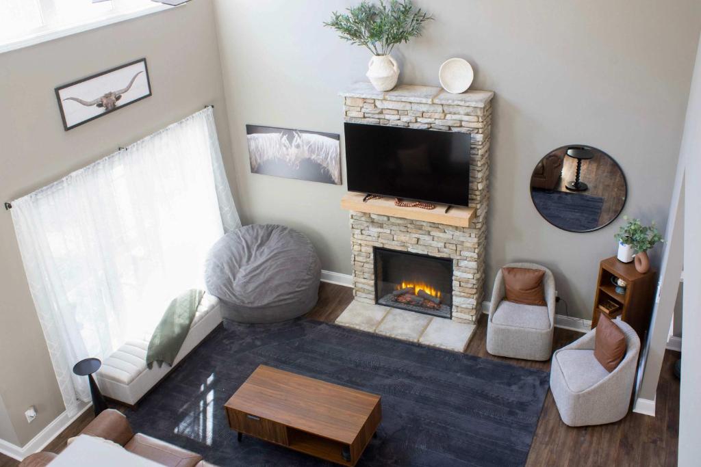 a living room with a fireplace and a television at Peach State Hideaway The Columbus Escape in Columbus