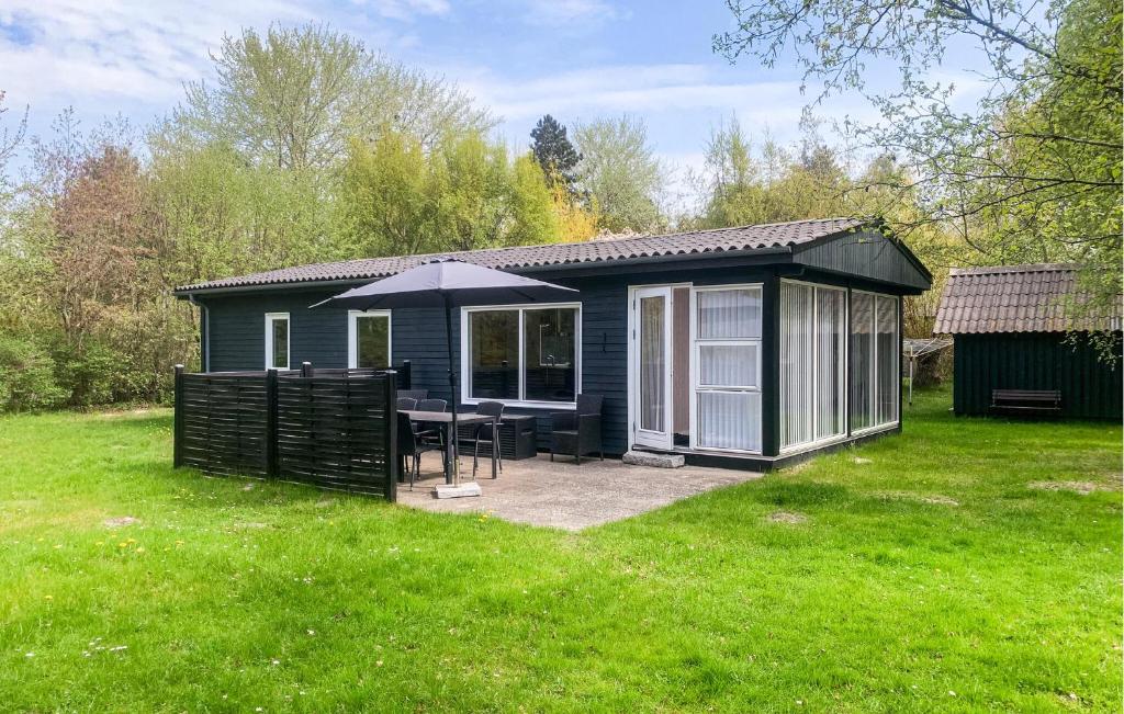 a blue shed with a table and an umbrella at Holiday Home Gedser 07 in Gedser
