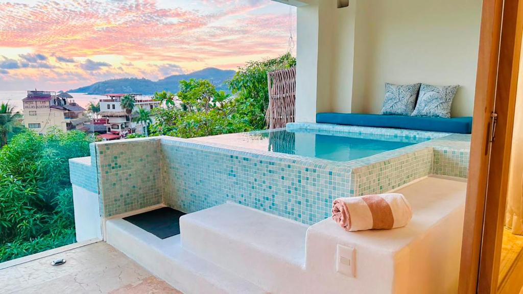 a balcony with a plunge pool with a view of the ocean at Villas Mimosa at La Ropa Beach in Zihuatanejo