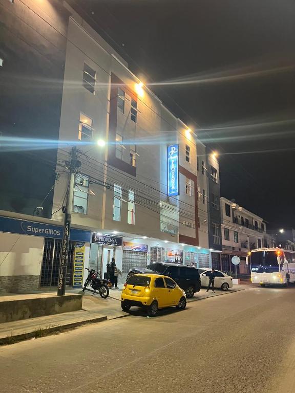a yellow car parked in front of a building at night at Hotel Provenza Suites in Ocaña