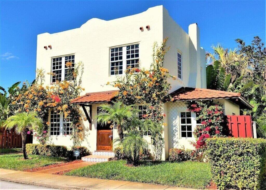 a white house with flowers in front of it at Casa de David from the 1920s Era in West Palm Beach