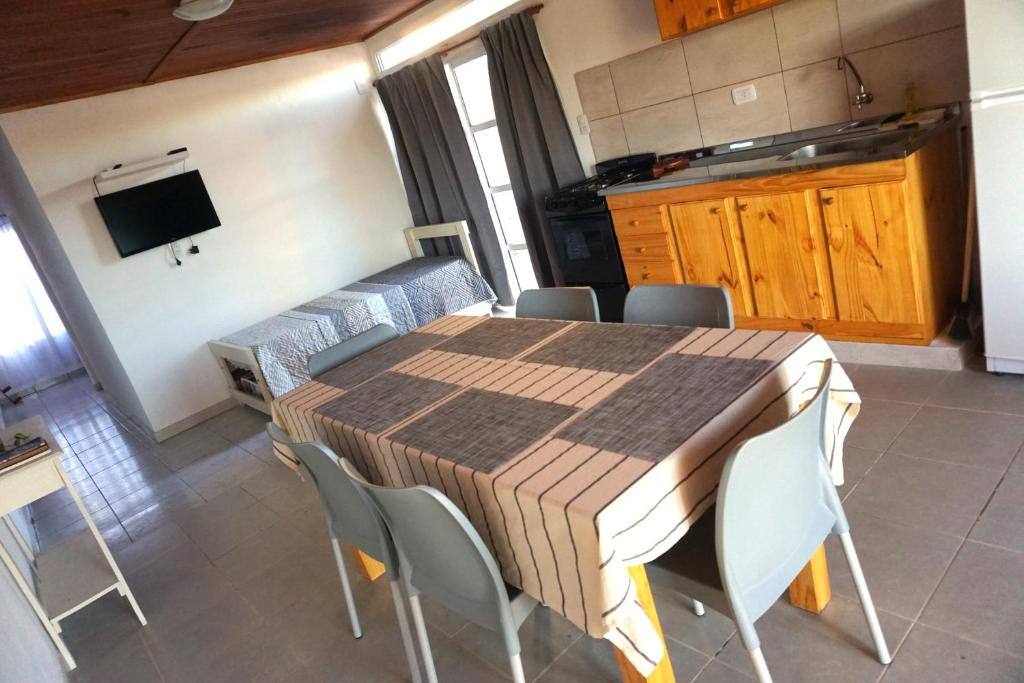 a kitchen with a table and chairs in a room at "ATARDECER" Departamento a pocos minutos de termas in Chajarí