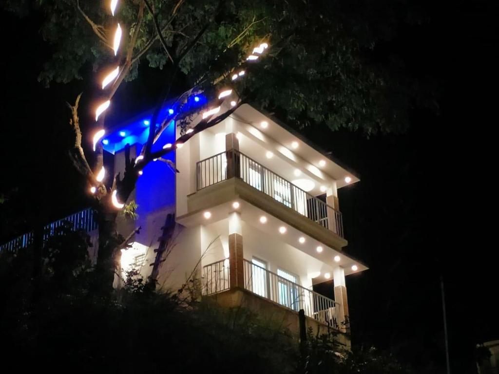 a white house with lights on it at night at Amber Mount Resorts in Kanthalloor