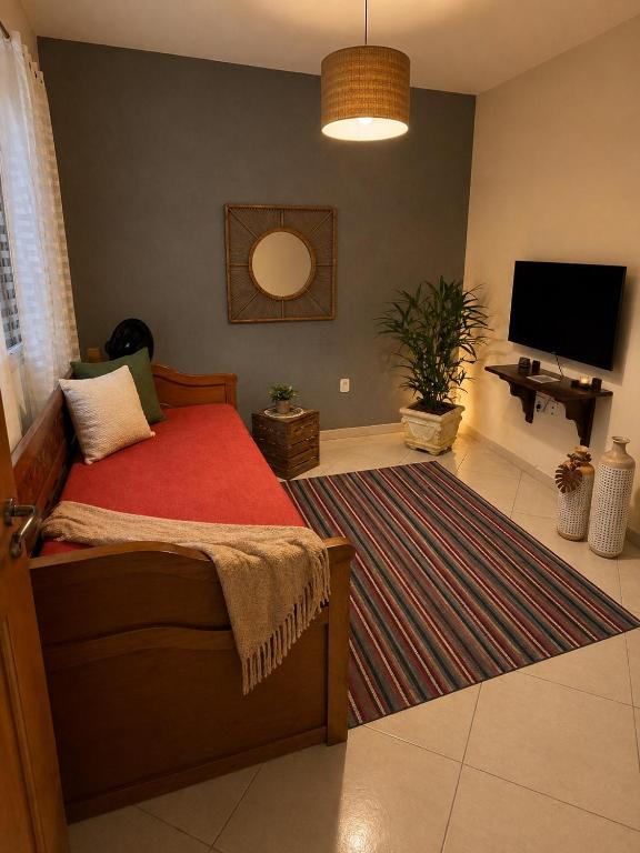 a bedroom with a bed and a flat screen tv at Elite na Serra in Cunha