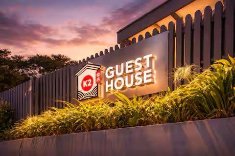 a guest house sign on the side of a building at K2 Guesthouse in Singapore