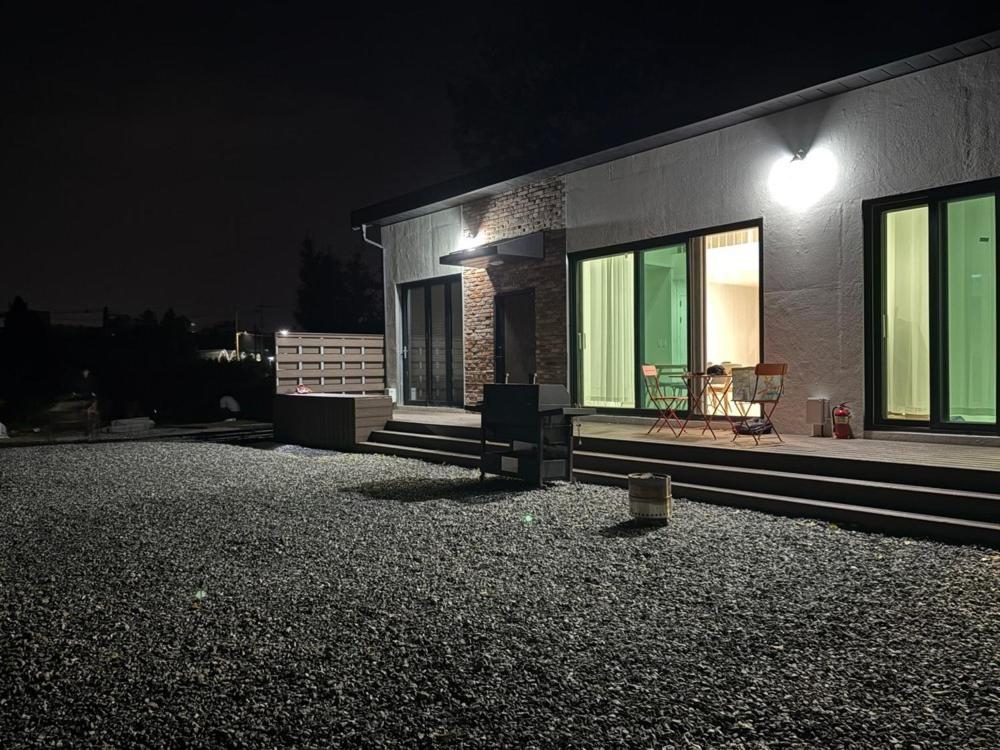 a house at night with a table and chairs outside at Nonsan Yeoyurowa Pension in Nonsan