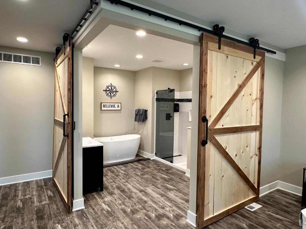 a bathroom with a sliding barn door and a tub at Grand River Suite in Bellevue