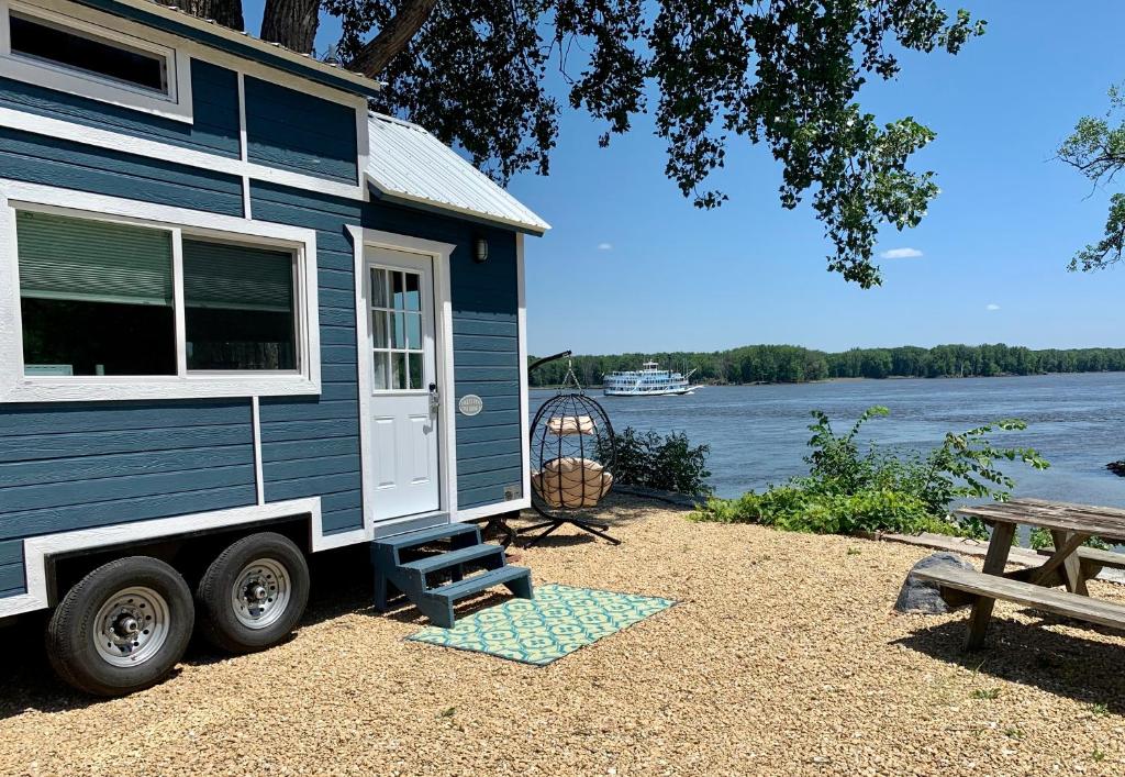 a blue tiny house parked next to a picnic table at The Eagle’s View (Tiny Home 4) in Bellevue