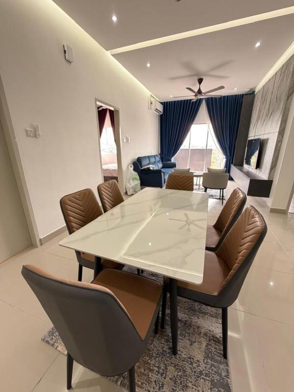 a dining room with a white table and leather chairs at Sufi Idaman Homestay for Islamic only in Nilai
