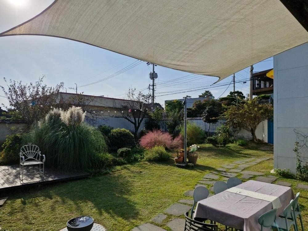 a patio with a table and chairs under a white umbrella at Jangheung Stay 1978 in Jangheung