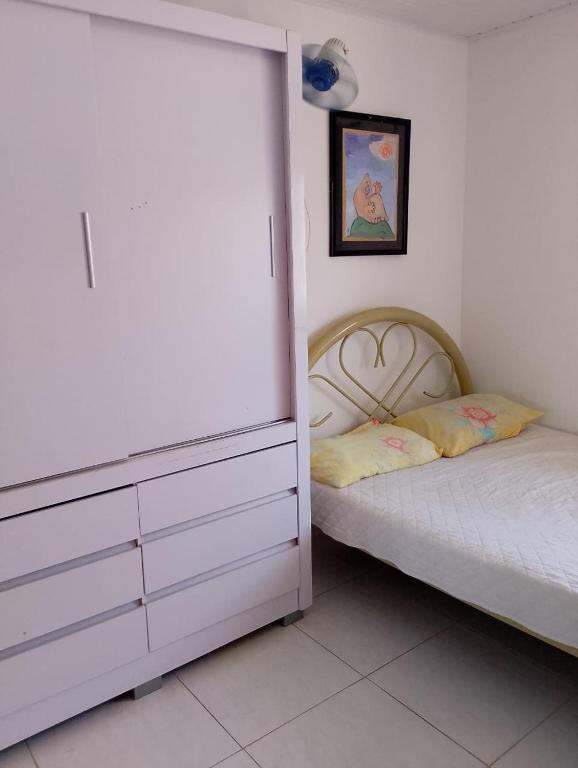 a bedroom with a bed next to a dresser and a bed sidx sidx sidx at Quarto Soleil in Aracaju