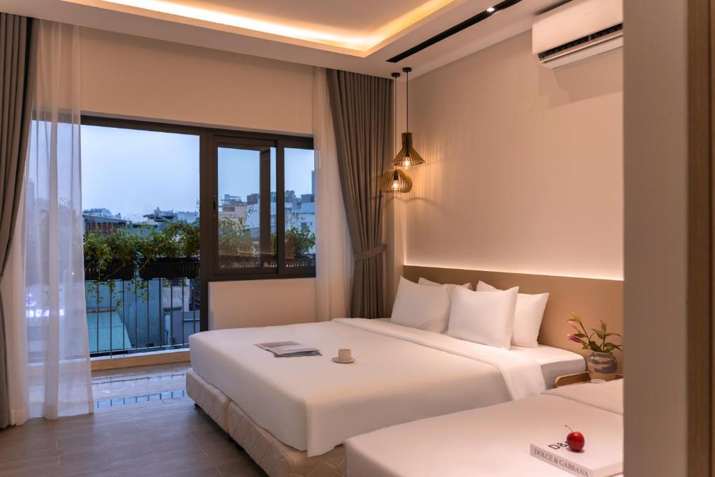a hotel room with two beds and a balcony at The Cozy Hotel in Ho Chi Minh City