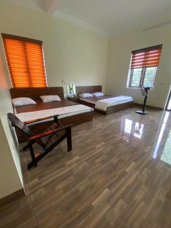 a bedroom with two beds and a wooden floor at Nhà của Mầm in Ninh Binh