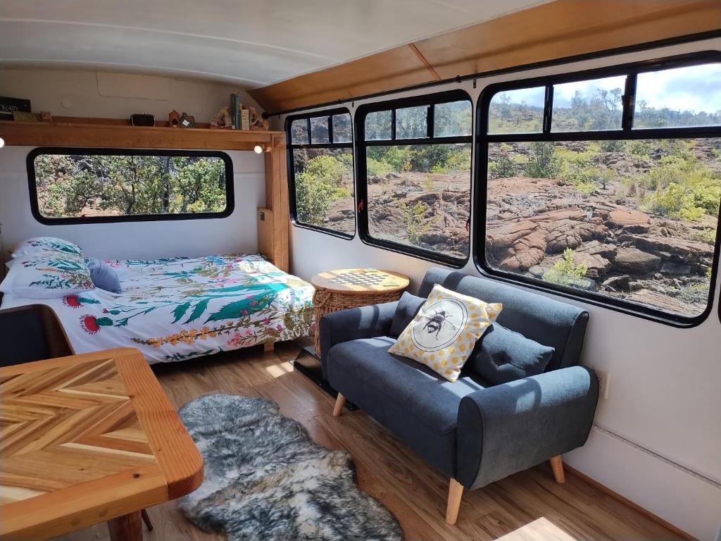 a living room with a bed and a couch in a bus at Lava Bus in Hawaiian Ocean View