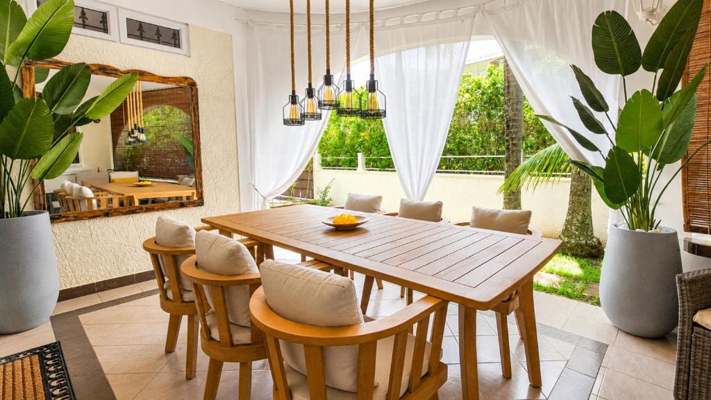 a dining room with a wooden table and chairs at Villa Agata Mauritius in Mont Choisy