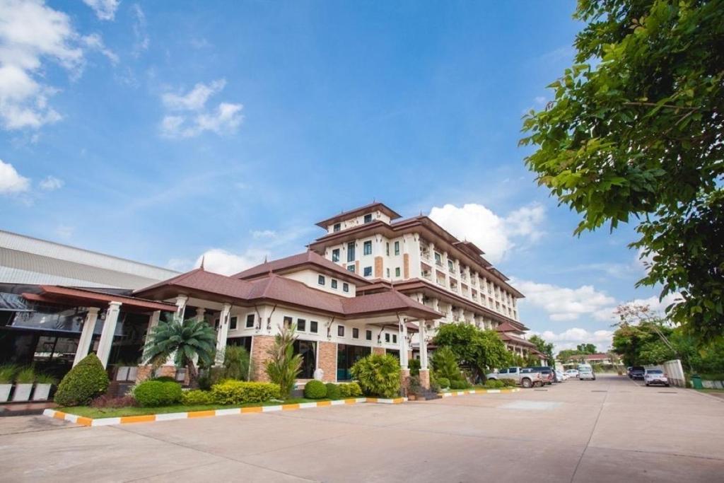 a large white building with a brown roof at Royal Nakhara Hotel and Convention Centre in Nong Khai