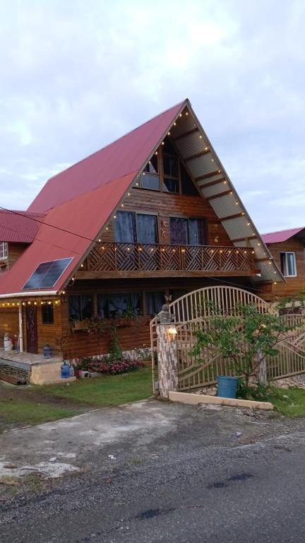 a large wooden house with a red roof at Mi Terraza Hostel in Almirante