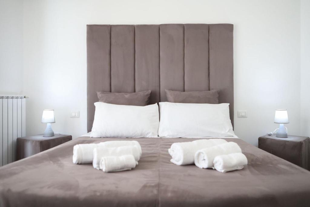 a large bed with three pillows on top of it at Airport bari grey in Bari