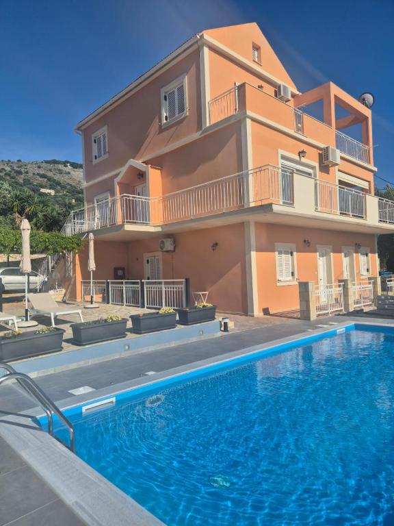 a villa with a swimming pool in front of a house at Apartments Marina House in Fársa