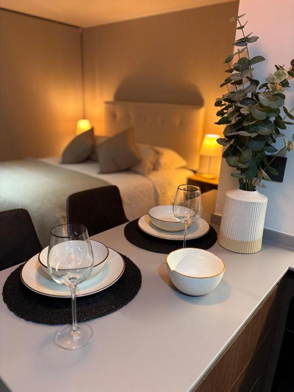 two plates and wine glasses on a counter in a bedroom at Nova Studio Dpto nuevo a pasos de Av Alemania in Temuco