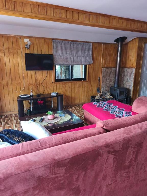 a living room with a couch and a fire place at Ventisqueros Coyhaique in Coihaique