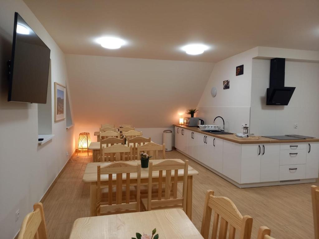 a restaurant with tables and a kitchen and a counter at Pokoje u Strażaka in Krościenko