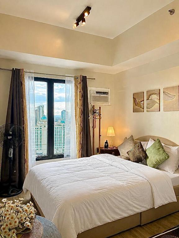a bedroom with a large bed and a large window at Peaceful Studio at The Median - City Skyline View, Short Walk to IT Park in Cebu City
