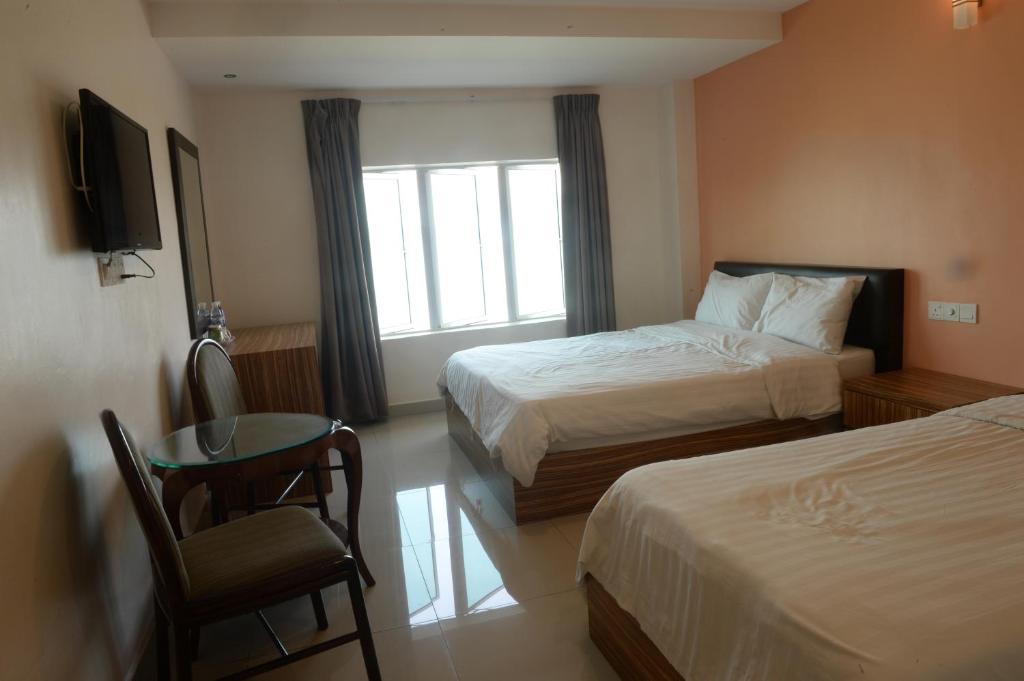 Postel nebo postele na pokoji v ubytování Brezza Hotel Lumut