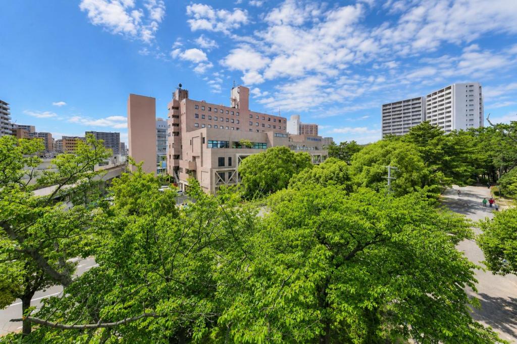 a view of a city with trees and buildings at Minamisenri Crystal Hotel in Suita
