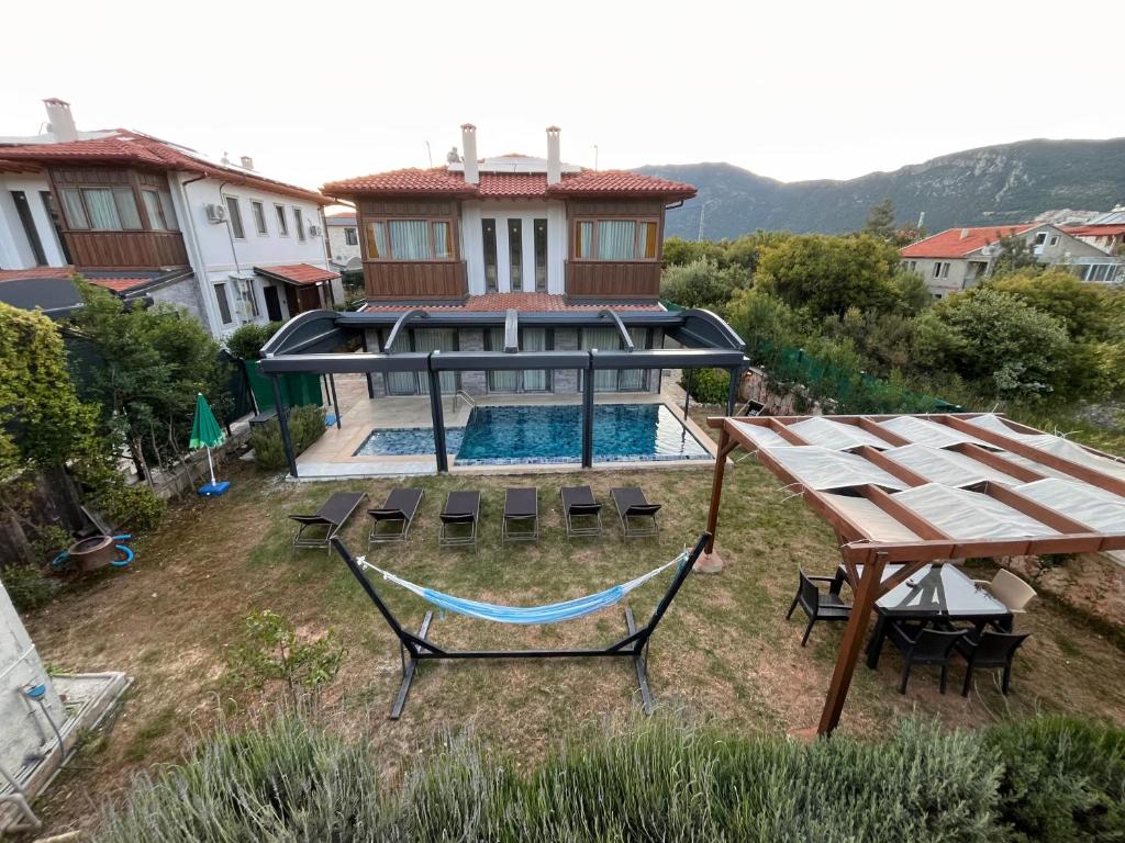 an aerial view of a house with a pool and a hammock at Derya Beach Ağullu Villa 2 in Kaş