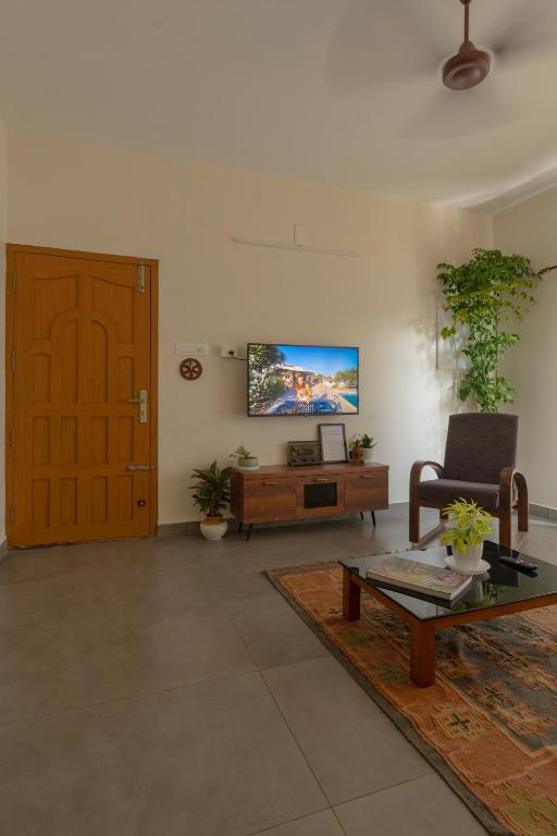 a living room with a tv on the wall at Sudama Cityscapes in Cochin