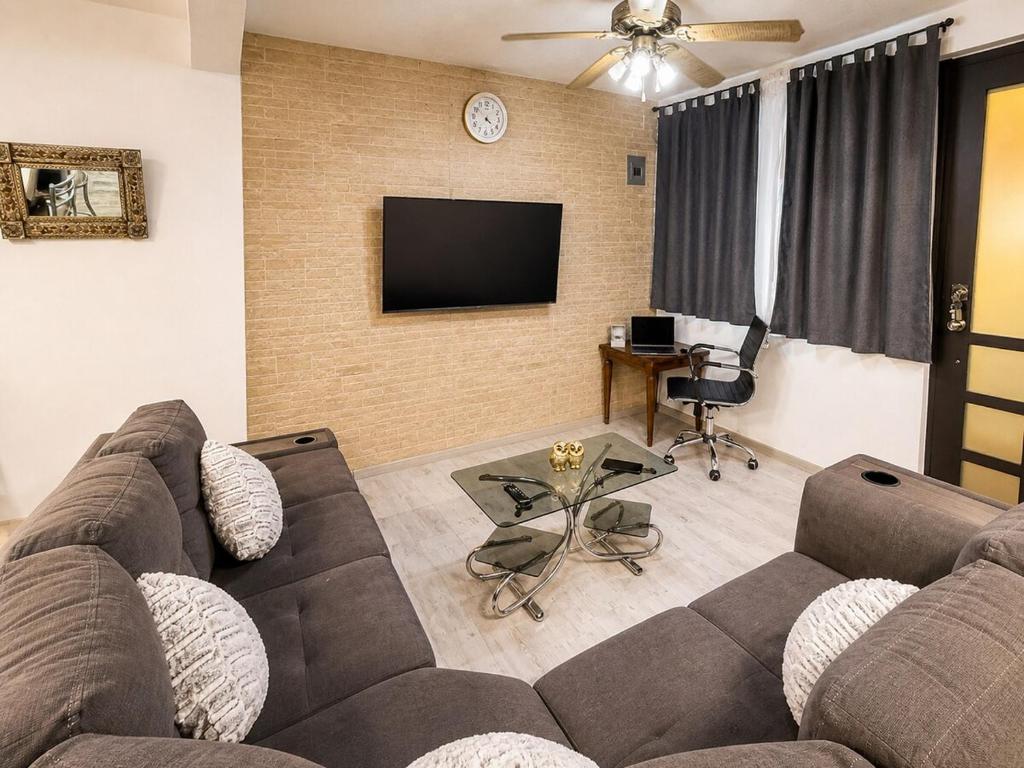 a living room with a couch and a flat screen tv at Departamento completo para 6 personas a 3 Min del Estadio Azteca-Banorte y muy cerca de la zona de Hospitales in Mexico City