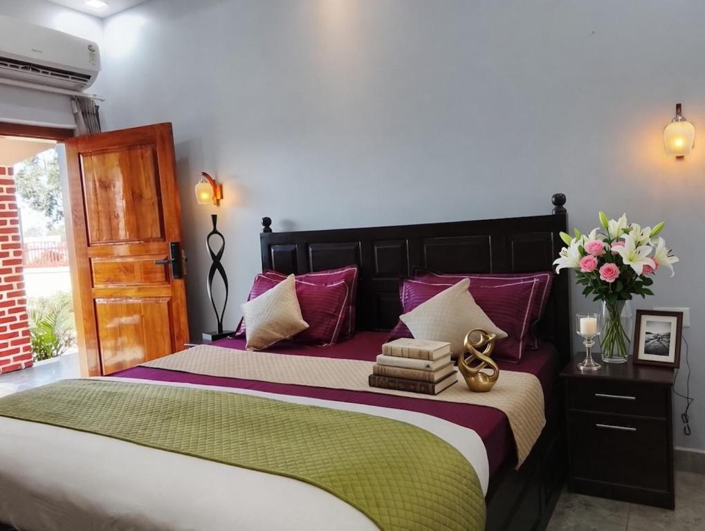 a bedroom with a large bed with purple and green sheets at Corbett Krishna Inn in Belparāo